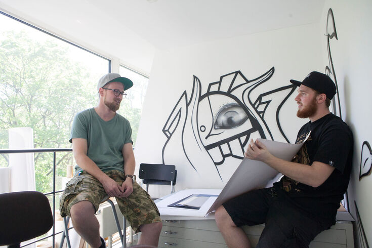 Students of the Design degree programme discuss poster designs.