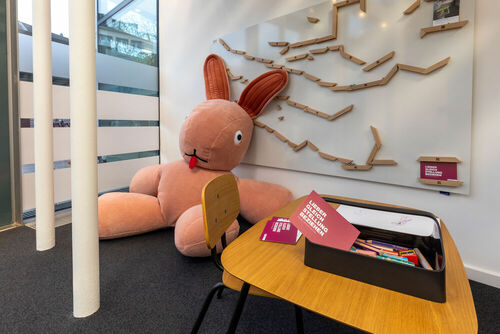Riesenhase Plüschtier vor einem Whiteboard mit Magnetkugelbahn und einem Tisch mit Stiften