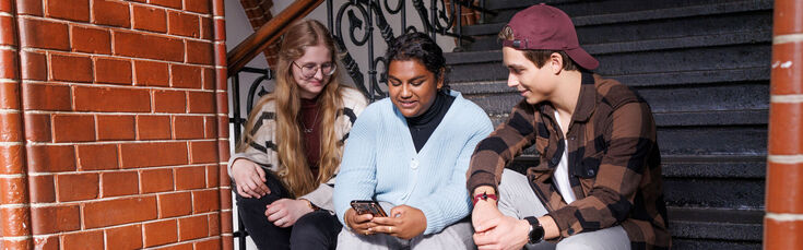 Students sit on the stairs in the main building of the Faculty of Textile and Clothing Technology