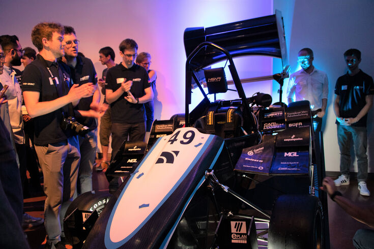 Gruppe Männer die HSNR Racing Auto angucken