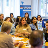 The mentee and mentor exchange ideas in a large group