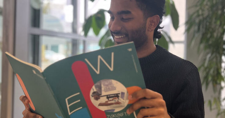 Student sits in the foyer and reads the new issue of Wege magazine
