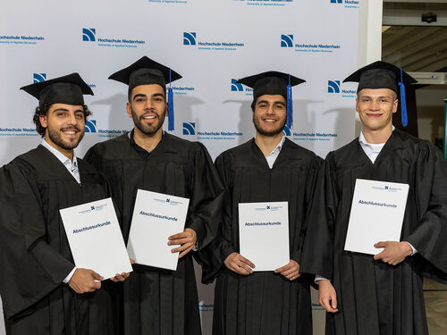 vier Absolvierende bei einer Abschlussfeier